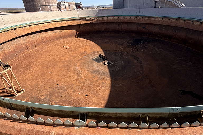 empty, rusty treatment plant clarifier tank