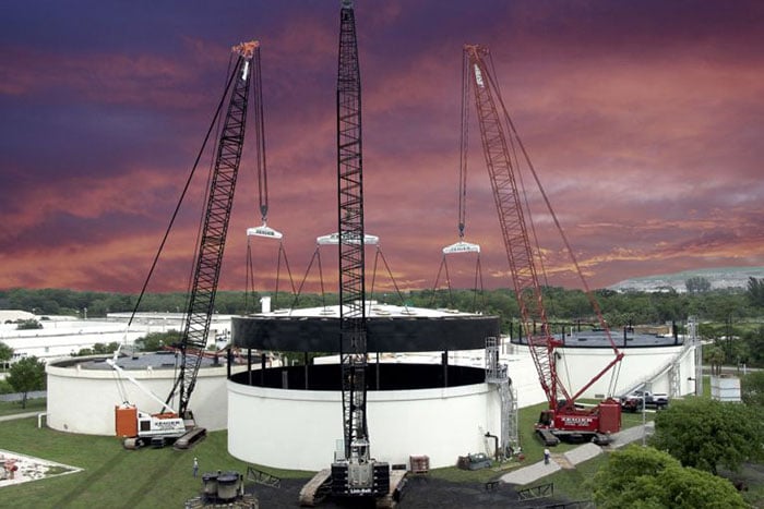 cranes lifting fully-assembled 100-foot truss gas holder into place