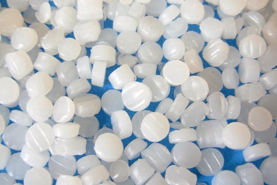 Closeup of buoyant media: small white cylindrical pellets scored at the ends to increase adsorption.