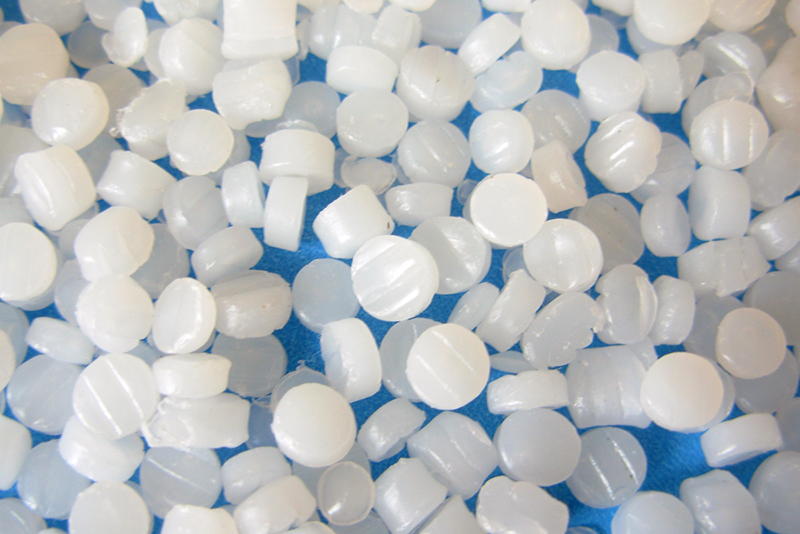 Closeup of buoyant media: small white cylindrical pellets scored at the ends to increase adsorption.