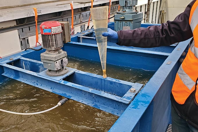 Worker collecting sample for jar testing.