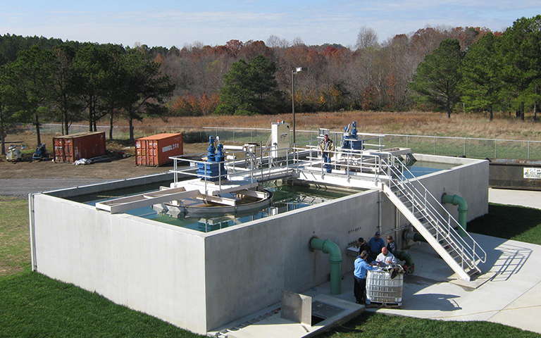 On-site rectangular structure with stair accessible bridge, structure houses 2 solids contact clarifiers, each with circular feedwell and drive motor.