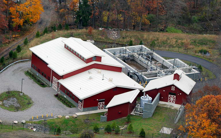 Aerial view of Peach Lake wastewater treatment plant including red barn themed structures and treatment train.