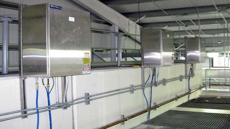 Three square interior-wall mounted aluminum control boxes spaced several feet apart.